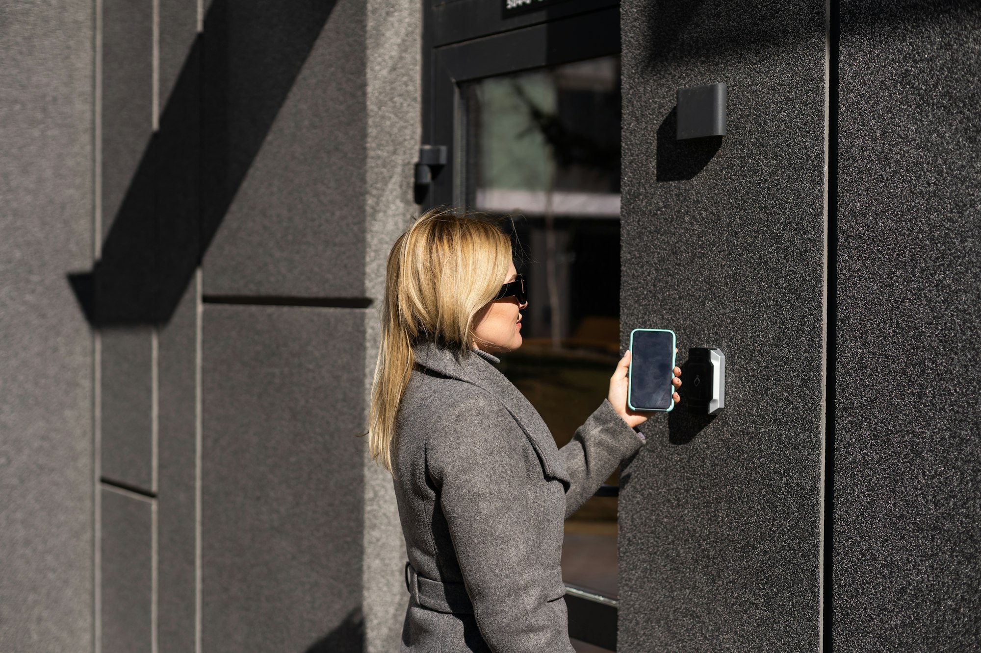 Woman hands using phone scan to digital door lock security systems at home.